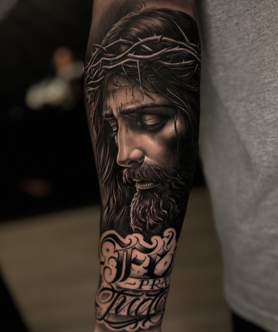Christ with the crown of thorns tattooed alongside chicano lettering