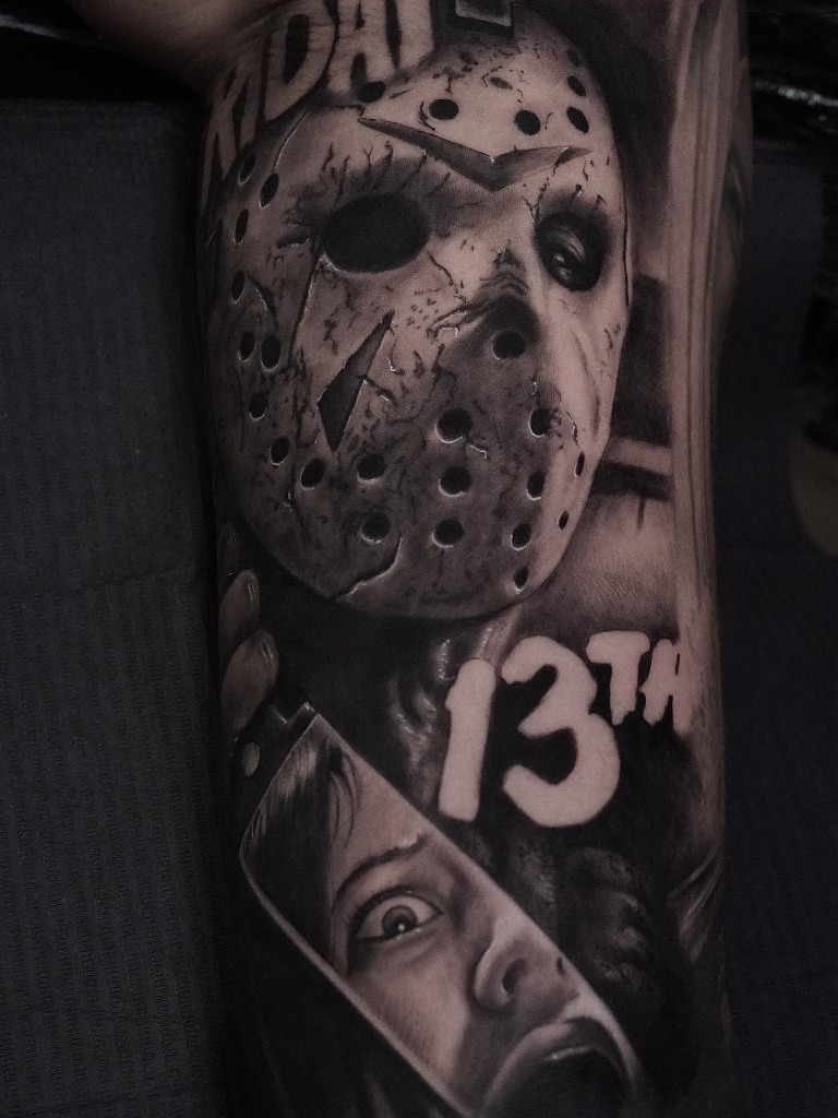 Jason Voorhees with hockey mask and victim reflection on knife blade tattooed in realism