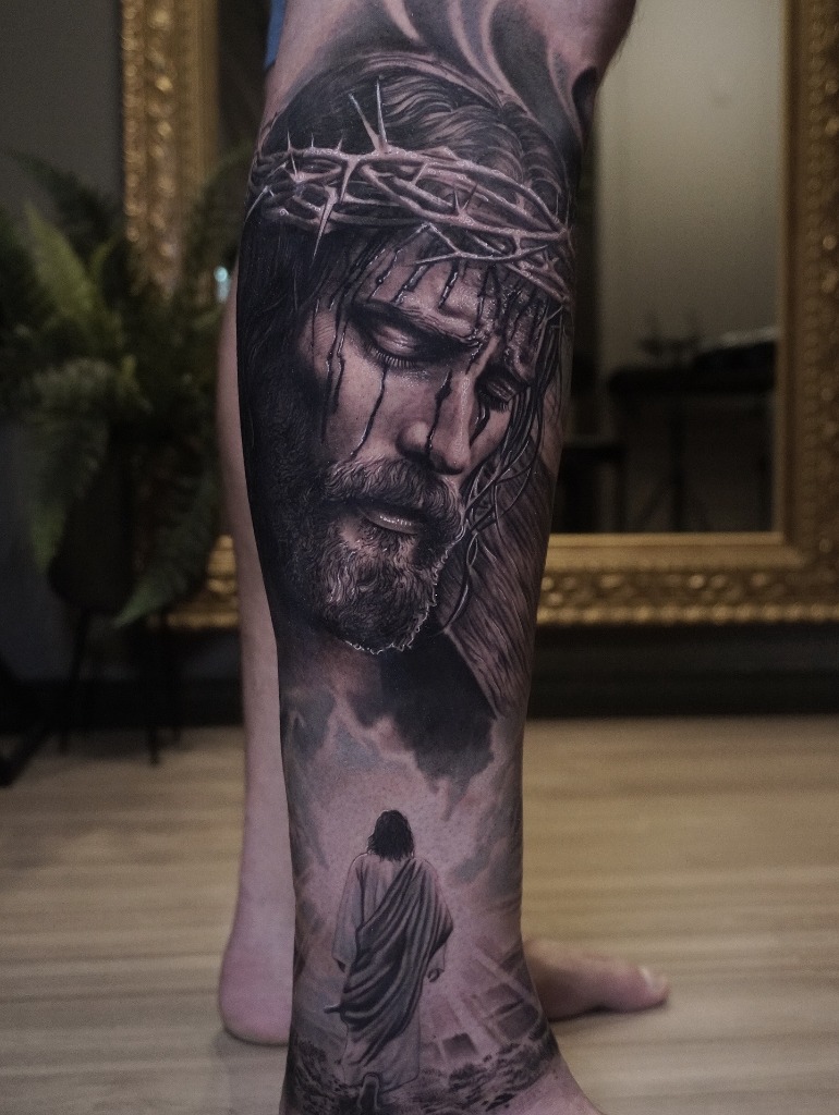 Christ with crown of thorns and walking into heavenly light tattooed in black and grey realism on a leg